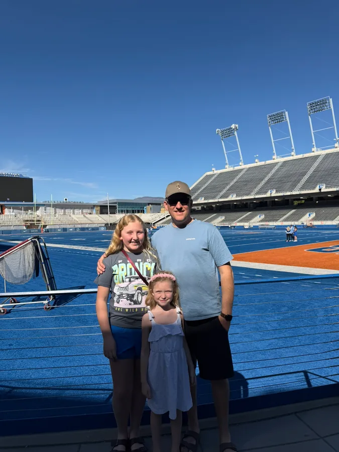 Phil with his kids on the blue turf at the Boise State stadium.