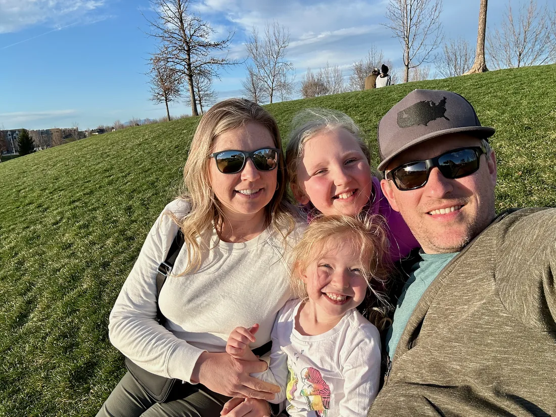 Phil with his family on a grassy hillside.
