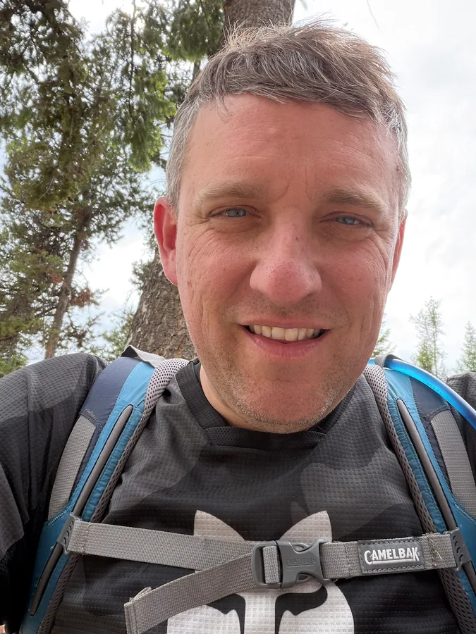Phil out on a trail wearing a daypack.